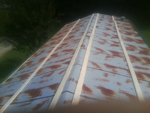 Rusted metal roof panels with new wood purlins before replacement — Storm Damage Roof Repair in Retsof by Roofing Brothers